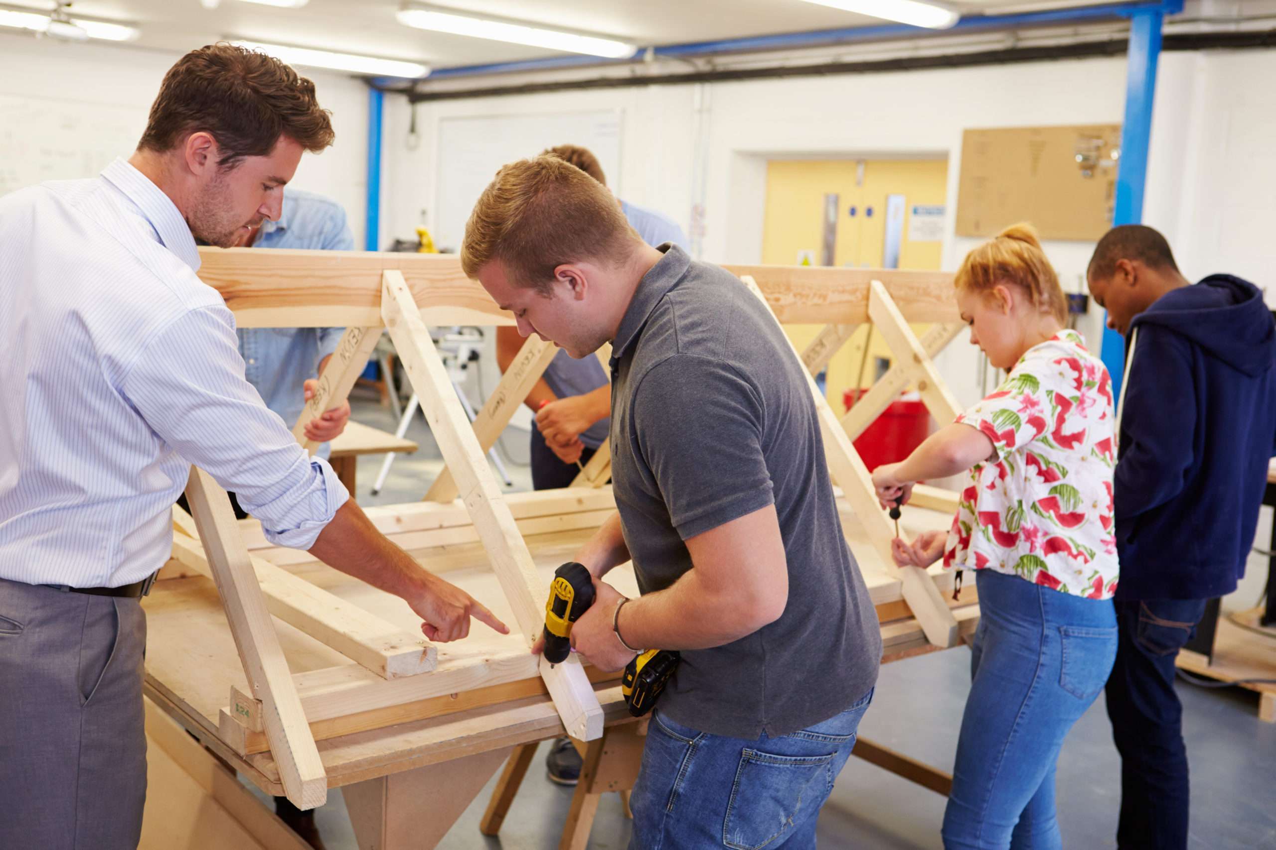 Teacher Helping Students Studying Carpentry